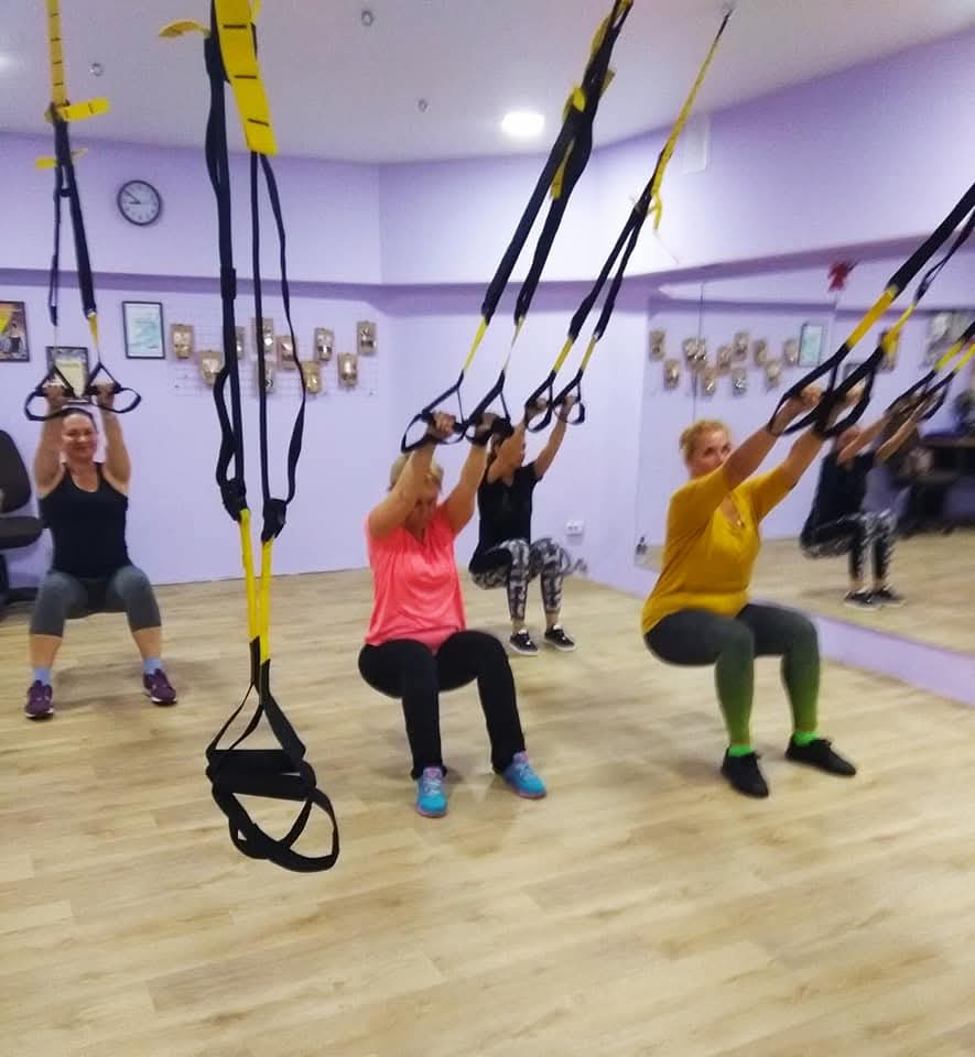 Frauengruppe trainiert mit TRX-Schlingen